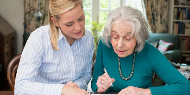 Woman Helping Senior Neighbor With Paperwork